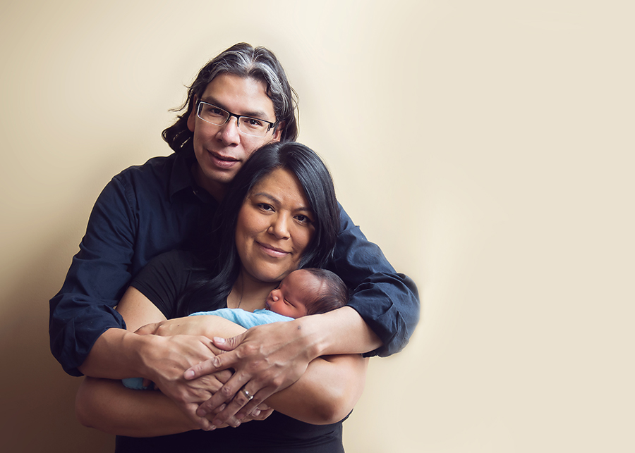 newborn baby boy in Calgary hugged by mom and dad